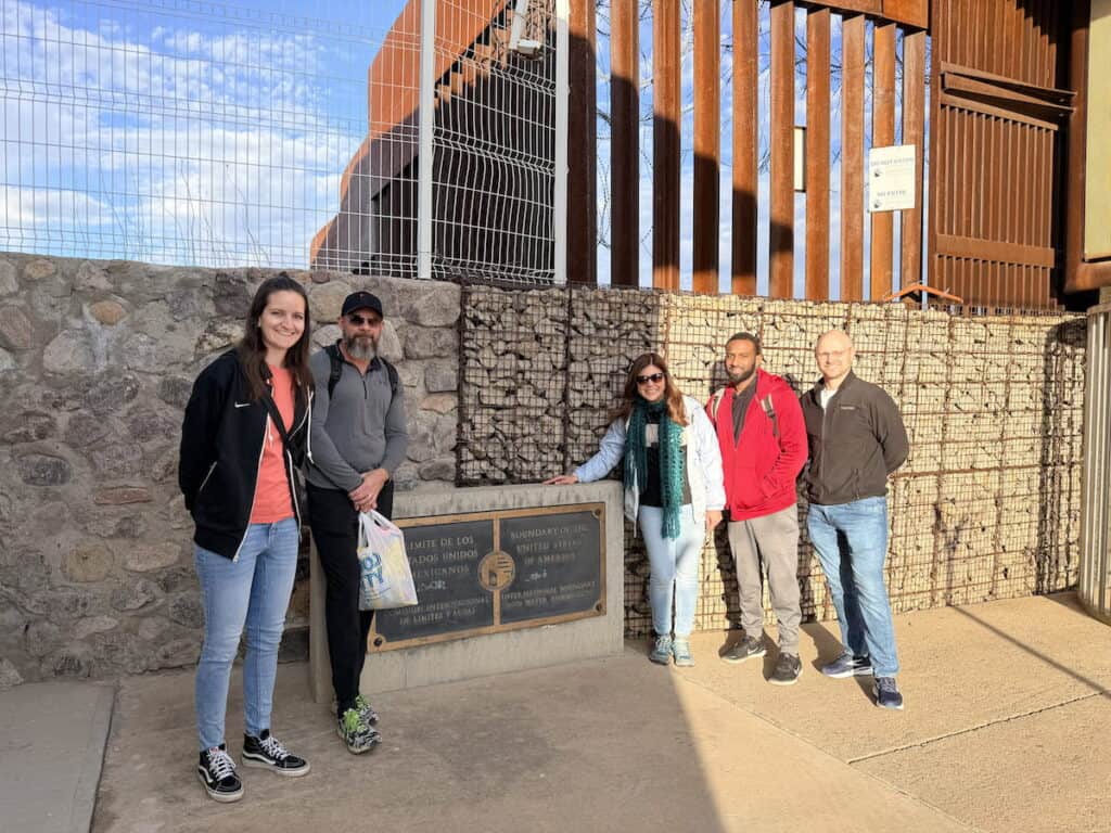 Group standing at the physical border between the United States and Mexico in Nogales