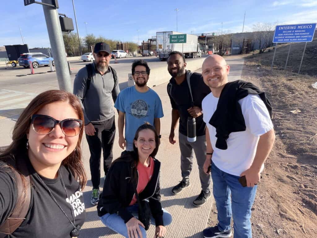 Group standing near a checkpoint before crossing into Mexico