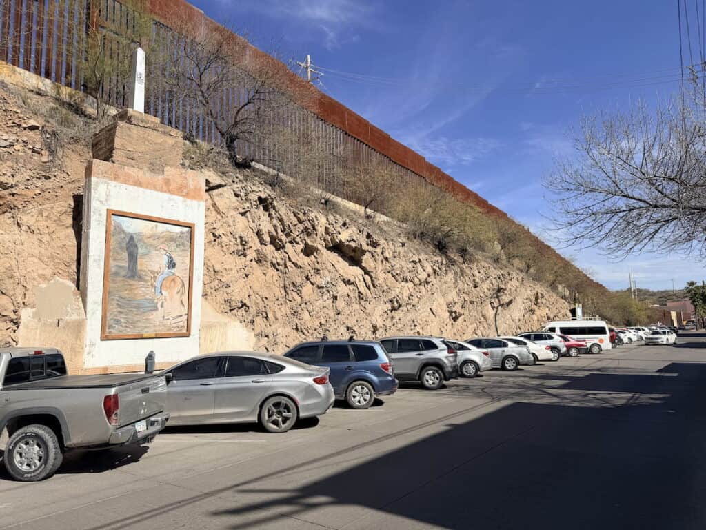 Border wall alongside a memorial honoring immigrants